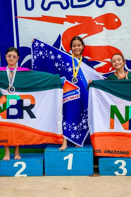 Lelê no pódio com a bandeira do Brasil