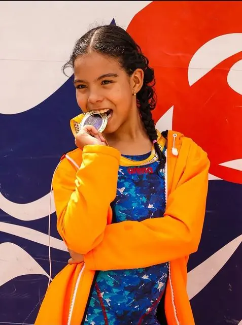 Lelê mordendo a medalha de prata